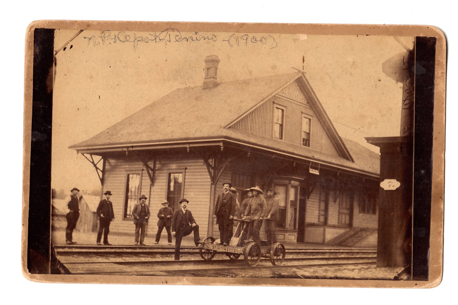 1876 to 1878 Depot:
The earliest known photo of Tenino. Four Chinese laborers stand on a Northern Pacific Railroad hand cart in front of the Tenino train depot. The man with his left leg propped on the wheel of the handcart is Billy Houston, who ran the hotel pictured in the photo from 1883. According to Tenino Historian Richard Edwards, Houston came into Tenino with the railroad in 1872 and left in about 1890.